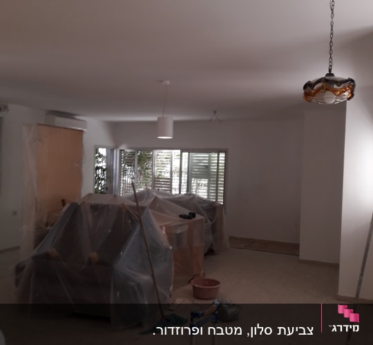 דלי צבע ומברשת על רצפה בחדר